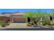 Desert home with a two-car garage and drought-resistant landscaping, including cacti and native plants at 6714 E Nightingale Cir, Scottsdale, AZ 85266