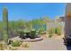 Back patio featuring a stylish outdoor table, mature landscaping, and desert views at 6714 E Nightingale Cir, Scottsdale, AZ 85266