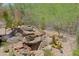 A backyard rock feature with desert plants surrounded by pea gravel and metal fencing at 6714 E Nightingale Cir, Scottsdale, AZ 85266