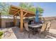 This backyard features a dining table with an umbrella, pavers, a hot tub, and a wood covered patio at 7238 N 126Th Ln, Glendale, AZ 85307