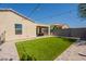 This backyard features turf, a covered patio, and easy-to-maintain desert landscaping at 7238 N 126Th Ln, Glendale, AZ 85307