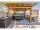 Enjoy the wood covered patio with a hot tub, dining table, and pavers in this backyard at 7238 N 126Th Ln, Glendale, AZ 85307