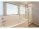 Bright bathroom featuring a tub and a glass enclosed shower at 7238 N 126Th Ln, Glendale, AZ 85307