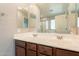 Bathroom featuring dual sinks, large vanity mirror, and wooden cabinets at 7238 N 126Th Ln, Glendale, AZ 85307