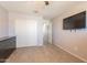 Bedroom with closet, mounted TV, ceiling fan, and neutral paint with tile floors at 7238 N 126Th Ln, Glendale, AZ 85307