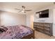 Bright bedroom with wood-look floors, ceiling fan and television mounted to the wall at 7238 N 126Th Ln, Glendale, AZ 85307