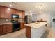Kitchen with stainless steel appliances, granite countertops, and dark wood cabinets at 7238 N 126Th Ln, Glendale, AZ 85307