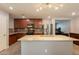 Bright kitchen with granite island, stainless steel refrigerator, and tile floors at 7238 N 126Th Ln, Glendale, AZ 85307