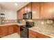 Close-up of kitchen with dark cabinets, black appliances, and mosaic tile backsplash at 7238 N 126Th Ln, Glendale, AZ 85307