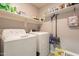Convenient laundry room with washer, dryer, and storage shelving at 7238 N 126Th Ln, Glendale, AZ 85307