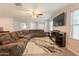 Cozy living room with a sectional sofa, tile floors, and a modern entertainment center at 7238 N 126Th Ln, Glendale, AZ 85307