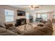 Spacious living room with a large sectional sofa, entertainment center, and tile floors at 7238 N 126Th Ln, Glendale, AZ 85307