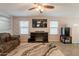Bright living room featuring an electric fireplace, tile floors, and large windows at 7238 N 126Th Ln, Glendale, AZ 85307