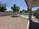 Backyard view featuring a fenced pool area and low-maintenance desert landscaping at 81 E Smoke Tree Rd, Gilbert, AZ 85296