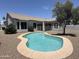 Beautiful pool with tanning ledge and clear blue water, surrounded by desert landscaping in backyard at 81 E Smoke Tree Rd, Gilbert, AZ 85296
