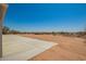Desert landscape featuring a large concrete patio, desert landscape, and sparse vegetation at 873 N Windy Meadow Ln, Maricopa, AZ 85139