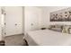 Cozy bedroom with large bed, neutral-colored walls, and adjacent bathroom entrance at 873 N Windy Meadow Ln, Maricopa, AZ 85139