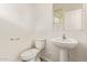 Well-lit half bath features a toilet, sink, and mirror, offering convenience for guests at 909 E Agua Fria Ln, Avondale, AZ 85323