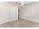 Neutral carpeted bedroom with a ceiling fan, closet, and a door leading to another room at 909 E Agua Fria Ln, Avondale, AZ 85323