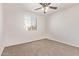Bright bedroom featuring neutral carpet, ceiling fan, and window offering natural light at 909 E Agua Fria Ln, Avondale, AZ 85323