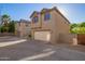 Two story home featuring a two car garage, desert landscaping, and a concrete driveway at 909 E Agua Fria Ln, Avondale, AZ 85323