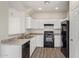 Modern kitchen featuring white cabinets, black appliances, and laminate counters at 909 E Agua Fria Ln, Avondale, AZ 85323