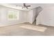 Spacious living room featuring carpet and a staircase to the second floor at 909 E Agua Fria Ln, Avondale, AZ 85323