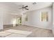 Bright living room with plush carpet, ceiling fan, and lots of natural light at 909 E Agua Fria Ln, Avondale, AZ 85323