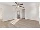 Bright bedroom has neutral carpet, ceiling fan, window, and a view into the bathroom at 909 E Agua Fria Ln, Avondale, AZ 85323