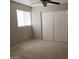 A well lit bedroom with neutral walls, carpet and ceiling fan and large closet at 1340 N Recker Rd # 154, Mesa, AZ 85205