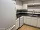 Kitchen area showcasing white appliances, including a refrigerator and dishwasher, with updated fixtures at 1340 N Recker Rd # 154, Mesa, AZ 85205