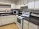 Functional kitchen with white cabinets, tile backsplash, and essential appliances at 1340 N Recker Rd # 154, Mesa, AZ 85205
