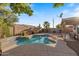 Private backyard pool with waterfall feature, surrounded by desert landscaping, brick walls, and covered patio at 1415 W Michigan Ave, Phoenix, AZ 85023