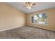 Carpeted bedroom with a ceiling fan and a window view of the backyard pool at 1415 W Michigan Ave, Phoenix, AZ 85023