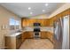 Well-equipped kitchen with stainless steel appliances, oak cabinets, and modern countertops at 1415 W Michigan Ave, Phoenix, AZ 85023