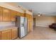 Kitchen showing oak cabinetry, granite countertops, stainless steel refrigerator, and tile flooring at 1415 W Michigan Ave, Phoenix, AZ 85023