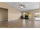 Bright living room featuring tile floors, neutral paint, a ceiling fan, and access to the backyard at 1415 W Michigan Ave, Phoenix, AZ 85023