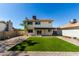 Spacious backyard with manicured artificial lawn, gravel landscaping, and covered patio at 1521 W Jacinto Ave, Mesa, AZ 85202