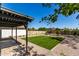 Backyard with artificial turf, well-maintained gravel landscaping, and covered patio at 1521 W Jacinto Ave, Mesa, AZ 85202