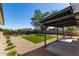 Backyard featuring gravel, artificial turf, mature landscaping, and a covered patio at 1521 W Jacinto Ave, Mesa, AZ 85202