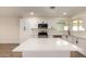 Modern kitchen features white cabinets, stainless appliances, and quartz counters with an island at 1521 W Jacinto Ave, Mesa, AZ 85202