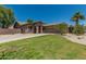 Beige single-story home featuring desert landscaping, green lawn and a two-car garage at 162 W Raven Dr, Chandler, AZ 85286