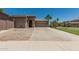 Beige single-story home featuring a wide driveway, a two-car garage and desert landscaping at 162 W Raven Dr, Chandler, AZ 85286