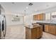 Bright kitchen featuring an island, tile floors, granite countertops, and natural wood cabinets at 162 W Raven Dr, Chandler, AZ 85286