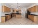 Spacious kitchen featuring wood cabinets, granite countertops, an island, and modern appliances, great for cooking at 162 W Raven Dr, Chandler, AZ 85286