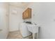 This laundry room includes a washer, dryer, sink, cabinet, and tile flooring at 162 W Raven Dr, Chandler, AZ 85286