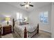 Bedroom featuring a queen bed, ceiling fan, and dual-shuttered windows at 1673 E Laddoos Ave, Queen Creek, AZ 85140