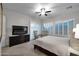 The serene bedroom features plantation shutters, ceiling fan, and a TV at 1673 E Laddoos Ave, Queen Creek, AZ 85140