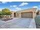 Charming tan stucco home featuring a two-car garage, desert landscaping, and a welcoming front entrance at 1673 E Laddoos Ave, Queen Creek, AZ 85140