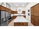 Well-designed kitchen featuring an island with a sink, wood cabinetry, and stainless steel appliances providing functionality at 1673 E Laddoos Ave, Queen Creek, AZ 85140